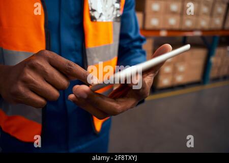 Midsection of a male worker pointing at digital tablet in factory Stock Photo