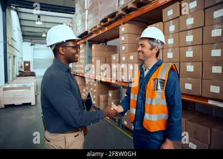 Multiracial engineers shaking hands with each others at manufacturing industry Stock Photo