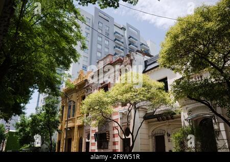 Old historical mansions in neighbourhood to modern multi-storey residential building. Rise up apartment building in modern style next to historic Stock Photo