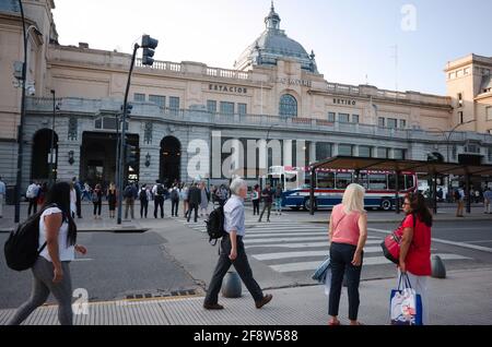 Buenos Aires, Argentina - January, 2020: A lot of people crossing road at pedestrian crossing near bus stop in front of main entrance to the building Stock Photo