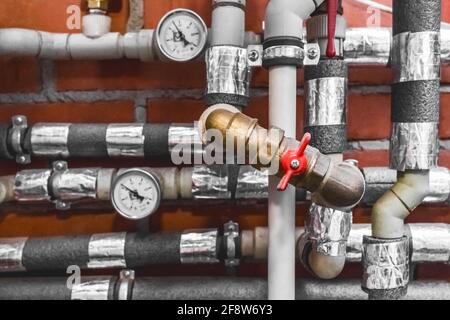 Insulated water pipe system valve. Heating unit at an industrial enterprise. Stock Photo