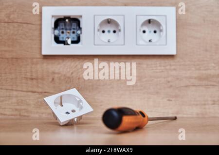 Broken socket and screwdriver on the table. Installing electrical socket i thekitchen Stock Photo