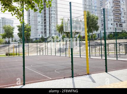 Basketball court from behind fence. Basketball hoop in the city park.  Selective focus, blurred background Stock Photo