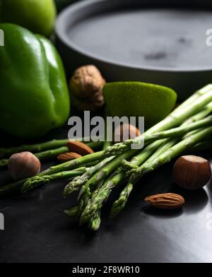 fresh asparagus with green vegetables. proper nutrition, keto diet. Low key, vertical position Stock Photo