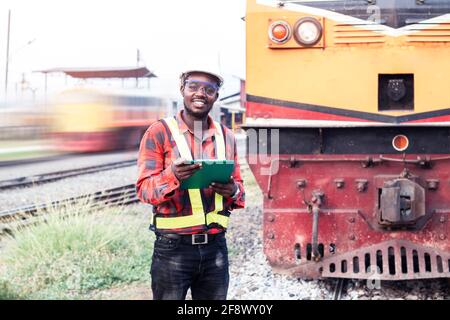 African man engineer looking report of Train Timetables for control a the train on railway Stock Photo