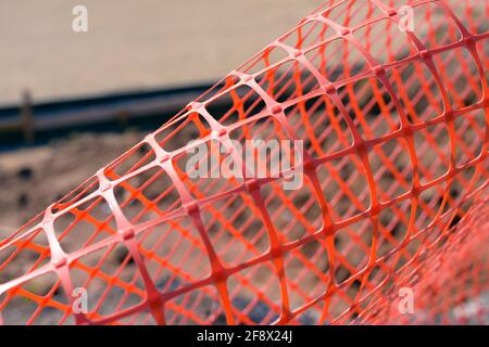 Plastic safety net for construction site. Construction mesh on winter snow background. Stock Photo