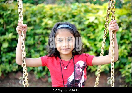 Mumbai; Maharashtra; India- Asia; Nov. 10, 2011 - Five Years Happy One Indian Little cute Girl Swinging Jhula In park. Stock Photo