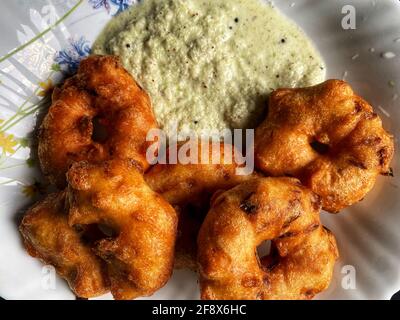 Plate of Vada - a South Indian snack with white coconut chutney. Healthy vegetarian food. Stock Photo