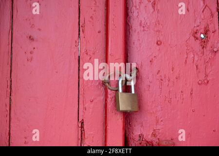 Padlock on red wooden door closeup, closed secured house entrance. Traditional door detail, Plaka Athens Greece Stock Photo