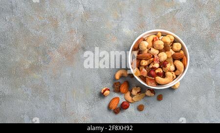 Mixed nuts and dried fruits on a gray background. Top view, copy space. Healthy snacks. Stock Photo
