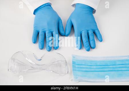 Medical products for the protection of medical personnel mask, blue examination gloves, latex and plastic goggles. Stock Photo