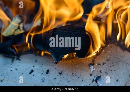 Spurts of flame. Burning wooden boards and logs. The bright flame of the fire. Combustible materials converted to coal, smoke  and ash by heat. Stock Photo