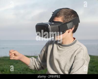 Teenager With Virtual Reality Glasses Playing Outdoor A Virtual Game Stock Photo