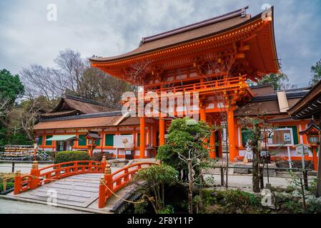 Kamigamo Jinja, a Shinto shrine in Kyoto, Japan. Religious Japanese architecture with small bridge and Torii gate painted red. Stock Photo