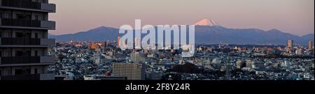 Mount Fuji towering over cityscape at sunrise, Tokyo, Japan Stock Photo