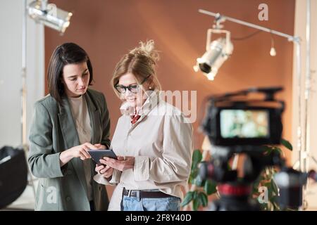 Business people watching something on digital tablet while working in recording studio Stock Photo