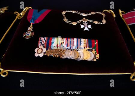 The Order of Merit, the Royal Victorian Chain, and Full Size Medal Group, sewn onto a cushion in St James's Palace, London. The cushions displaying medals and decorations conferred on the Duke of Edinburgh by the United Kingdom and other countries across the world, together with his Field Marshal's baton and Royal Air Force Wings, and insignia from Denmark and Greece, will be placed on the altar in St George's Chapel, in Windsor, ahead of his funeral on Saturday. Picture date: Tuesday April 13, 2021. Stock Photo