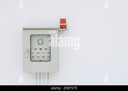 Power box for industry building electricity circuit breakers fuse switch panel with rotating alarm buzzer on white wall Stock Photo