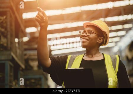 Black African professional women worker happy working count checking inventory production stock control in business factory  industry warehouse waring Stock Photo