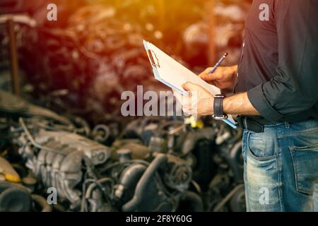 Engineer employee working with manager checking stock inventory in garage used engine car part store Stock Photo