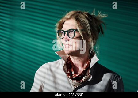Portrait of mature elegant businesswoman in eyeglasses standing against the green background at office Stock Photo