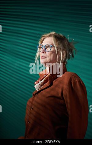 Elegant mature businesswoman in brown blouse looking away against the green background Stock Photo
