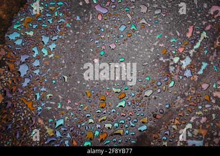 Oil stain on Asphalt road after rain. Abstract close-up background. Stock Photo