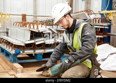 Construction worker on Building site tightens circular blade on angle grinder Stock Photo