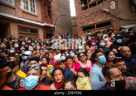 Bhaktapur, Nepal. 15th Apr, 2021. People observe as devotees celebrate Sindoor Jatra vermillion powder festival. Revelers carried chariots of the Hindu gods and goddesses and hurled vermillion powder onto each other as part of the celebrations commencing Nepalese New Year. Credit: SOPA Images Limited/Alamy Live News Stock Photo
