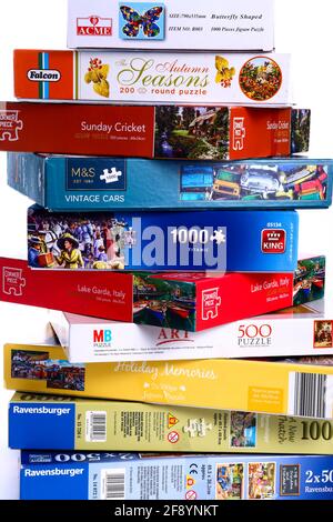 Stack of jigsaw puzzle boxes waiting to be solved Stock Photo