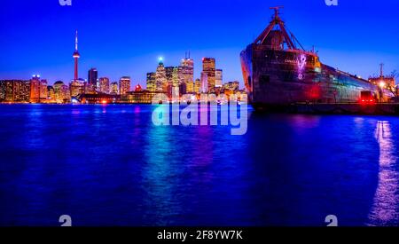 Skyline at night on shore of Lake Ontario and container ship, Toronto, Ontario, Canada Stock Photo