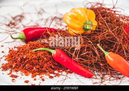 Chili pods, flakes and threads on white background, closeup Stock Photo