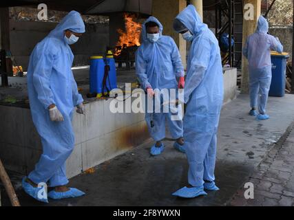 Mumbai, India. 15th Apr, 2021. Municipal workers wearing personal protective equipment suites (PPE) sanitize themselves after cremating a person who died due to coronavirus disease in Mumbai.Amidst the rising in coronavirus cases in Maharashtra, there is a 15 days of curfew starting from 14th April till 30th April, only essential service will be allowed. (Photo by Ashish Vaishnav/SOPA Images/Sipa USA) Credit: Sipa USA/Alamy Live News Stock Photo