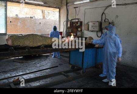 Mumbai, India. 15th Apr, 2021. (Editors note image depicts death)Municipal workers wearing personal protective equipment suite (PPE) cremates a person who died due to coronavirus disease in Mumbai. Amidst the rising in coronavirus cases in Maharashtra, there is a 15 days of curfew starting from 14th April till 30th April, only essential service will be allowed. (Photo by Ashish Vaishnav/SOPA Images/Sipa USA) Credit: Sipa USA/Alamy Live News Stock Photo