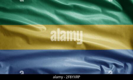 Gabonese flag waving in the wind. Close up of Gabon banner blowing, soft and smooth silk. Cloth fabric texture ensign background. Use it for national Stock Photo