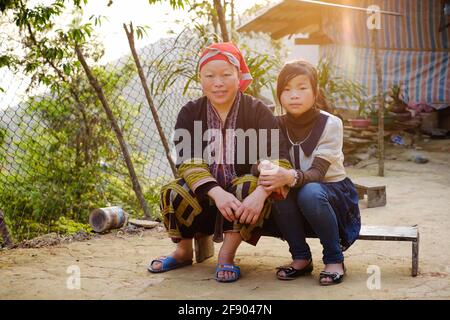 Sapa, Vietnam - April 15: Portrait of Red Dzao ethnic minority family in traditional clothes. Wife and daughter near the home.  Stock Photo