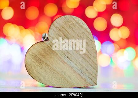 Wooden heart shaped Christmas ornament. Christmas decorations on blurred lights background. Stock Photo