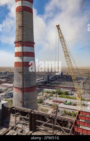 Aerial view of GRES-1 steam power station.Demolition of old raw coal bunkers.Yellow crane, smoke stack.Coal harvesters,dust and conveyor on background Stock Photo
