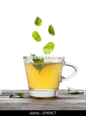 Green  tea with falling mint leaves in glass cup isolated on white Stock Photo