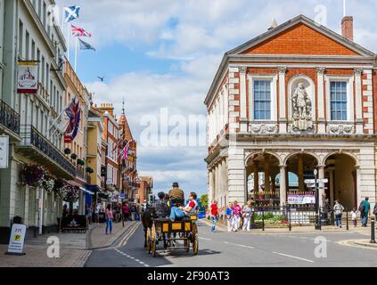 A tourist horse and cart excursion passes the Windsor & Royal Borough Museum in the Guildhall in Windsor town centre on a sunny day Stock Photo