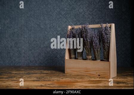 Composition of dried flowers in a wooden basket on dark background Stock Photo