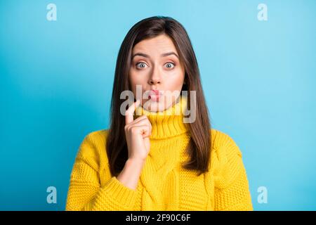 Photo of doubtful sweet adorable young lady wear yellow sweater finger chin lips pouted isolated blue color background Stock Photo