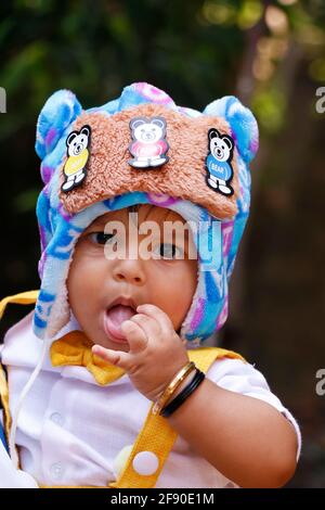 eight months old indian baby boy wearing fancy cloth cap in close up Stock Photo