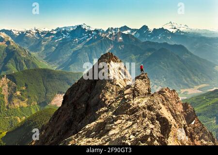 Mountain climber stands on mountain summit in British Columbia, Canada Stock Photo