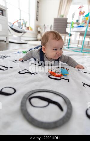 Happy baby boy crawling on blanket. Stock Photo