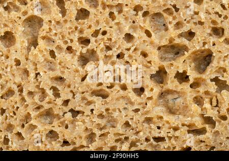 Surface of a fresh cut rye bread, close-up from above. Brown colored sourdough bread, a mix of rye grain flour, leaven and spices, baked in an oven. Stock Photo