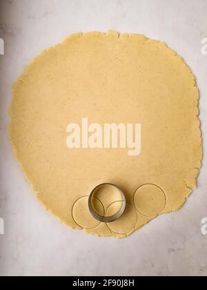 Roll out the dough and cut with a roung metal cookie cutter top view Stock Photo