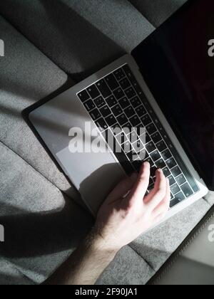 Man's hand on the laptop keyboard. Top view. Stock Photo