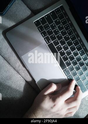 Man's hand on the laptop keyboard. Top view. Stock Photo