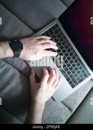 Man's hands on the laptop keyboard. Top view. Stock Photo